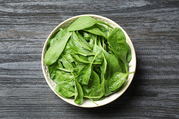 Fresh green healthy spinach on dark wooden table, top view - Foto, Imagem
