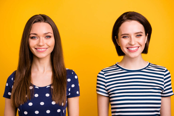 Close up photo of two amazing positive ladies with lovely beaming smile in good mood wear summer casual t-shirts isolated yellow background - Foto, Bild