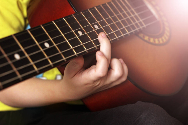 Cuerdas de mano y guitarra para niños, aprendiendo a tocar
 - Foto, Imagen