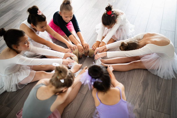Group of fit children exercising ballet in studio together - Fotó, kép