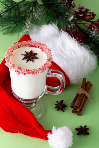 Two glasses of eggnog on green background. Traditional Christmas beverage. - Photo, Image