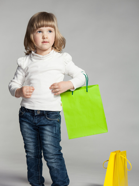 Smiling little girl holding shopping bag - Foto, imagen