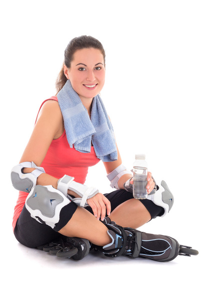 νεαρή γυναίκα που κάθεται με κυλίνδρους στα πόδια και μπουκάλι νερό - Φωτογραφία, εικόνα