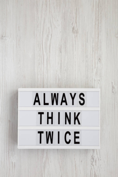 "Mindig gondold meg kétszer" szavak egy villanydobozon egy fehér fa háton - Fotó, kép