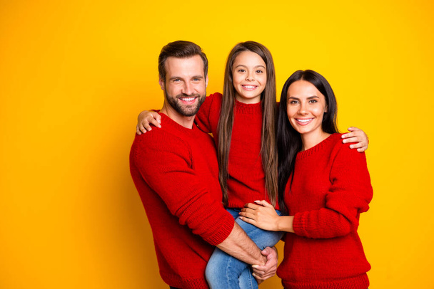 Photo of cheerful cute nice fascinating family embracing each other affectionately wearing jeans denim hands holding enjoying joint leisure isolated over vivid color yellow background - Foto, afbeelding