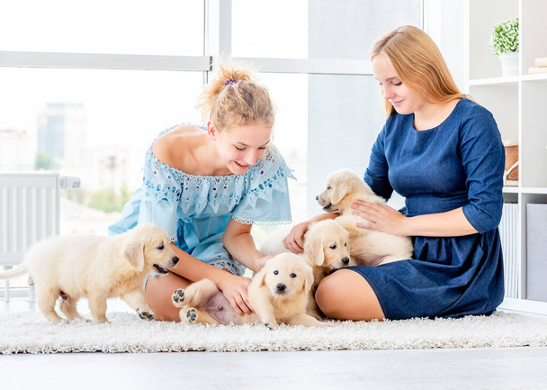 Girls playing with puppies - Fotoğraf, Görsel