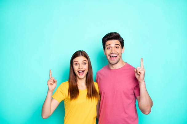 Portrait of his he her she nice attractive charming friendly cheerful glad couple hugging pointing up ad advert new tips feedback isolated over bright vivid shine vibrant green turquoise background - 写真・画像