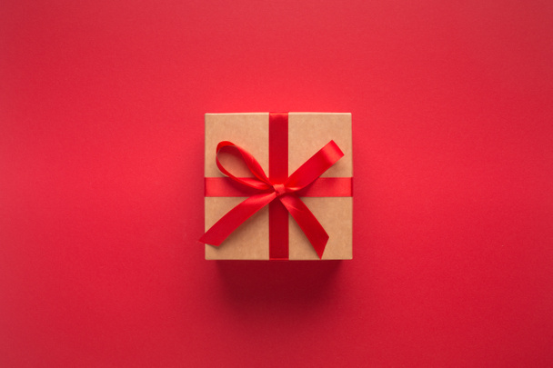Neujahrsgeschenk mit Band isoliert auf rotem Hintergrund - Foto, Bild