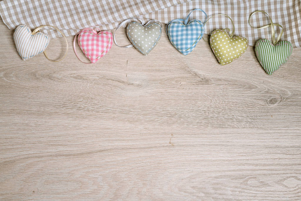 Φόντο για ευχετήρια κάρτα με γεμιστές καρδιές βαμβακιού στο ξύλο - Φωτογραφία, εικόνα