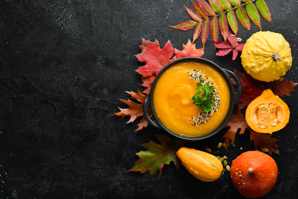 Autumn composition: Pumpkin soup with pumpkin and colored autumn leaves. flat lay. On a white wooden background. Top view. Free space for your text. - Zdjęcie, obraz