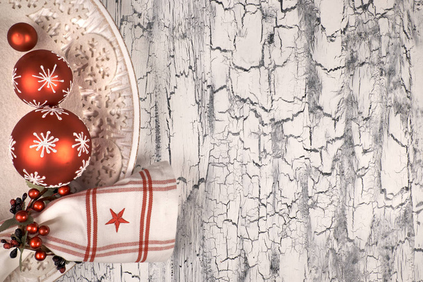 Διακοσμητικό πιάτο με κόκκινα στολίδια Χριστουγέννων σε ρουστίκ φόντο - Φωτογραφία, εικόνα
