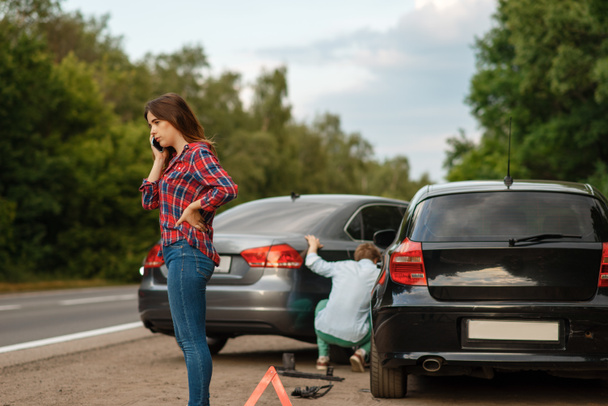 Male and female drivers on road, car accident. Automobile crash. Broken automobile or damaged vehicle, auto collision on highway - Photo, Image