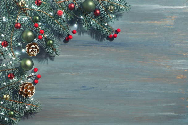 Χριστουγεννιάτικο φόντο με κλαδιά ελάτης, κόκκινα μούρα, κώνους και Χριστούγεννα - Φωτογραφία, εικόνα