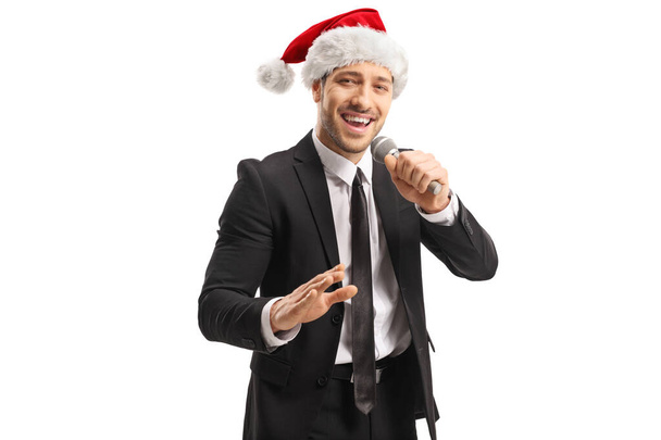 Muž zpěvák s kloboukem Santa Claus zpívající o Vánocích - Fotografie, Obrázek