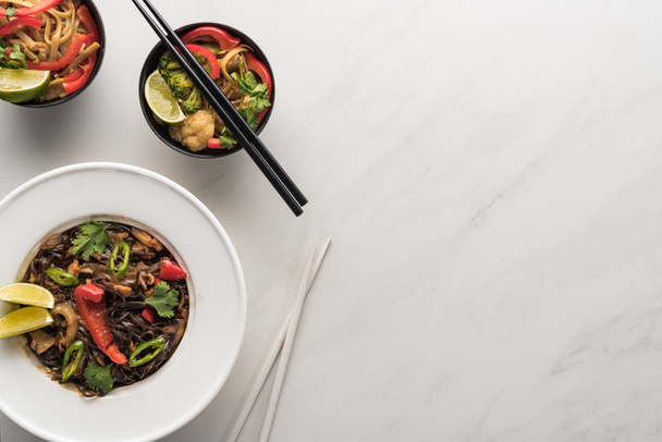 top view of delicious spicy thai noodles with chopsticks on marble grey surface - Fotografie, Obrázek