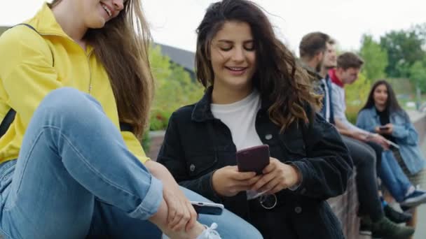 Grupo de jóvenes con teléfono inteligente que pasan tiempo juntos
  - Metraje, vídeo
