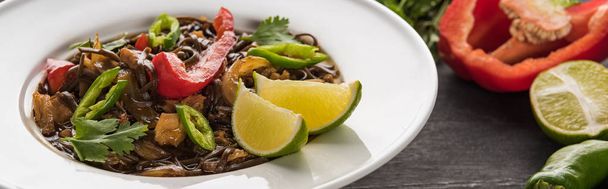крупным планом вид на мясо тайской лапши рядом с ингредиентами на деревянной серой поверхности, панорамный снимок
 - Фото, изображение