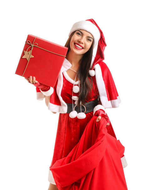 schöne junge Frau im Weihnachtsmann-Kostüm mit Tasche und Geschenken auf weißem Hintergrund - Foto, Bild
