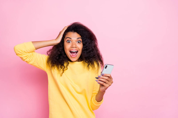 Omg followers get more in blog. Portrait of excited funky hipster african girl use cellphone get notification from social network scream wow wear trendy clothes isolated over pink color background - Foto, imagen
