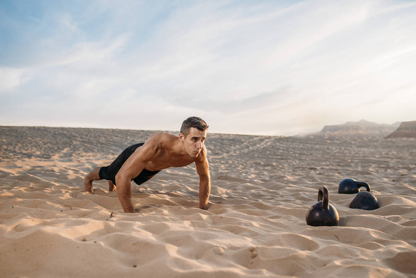 Sportovec dělá push-up cvičení v poušti za slunečného dne. Silná motivace ve sportu, silný venkovní trénink - Fotografie, Obrázek