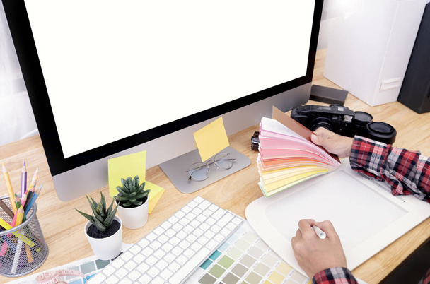 Projektant graficzny korzystający z rysunku tablicy graficznej i przeglądający schemat kolorystyczny swojej pracy w biurze. - Zdjęcie, obraz