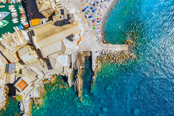 Widok z lotu ptaka na Camogli. Zamek della Dragonara w pobliżu liguryjskiej plaży morskiej. Widok z góry na skałę i morze z przezroczystą turkusową czystą wodą i kamieniami na dnie. - Zdjęcie, obraz