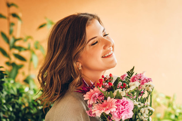 Romantikus portré gyönyörű fiatal nő kis csokor rózsaszín virágok - Fotó, kép