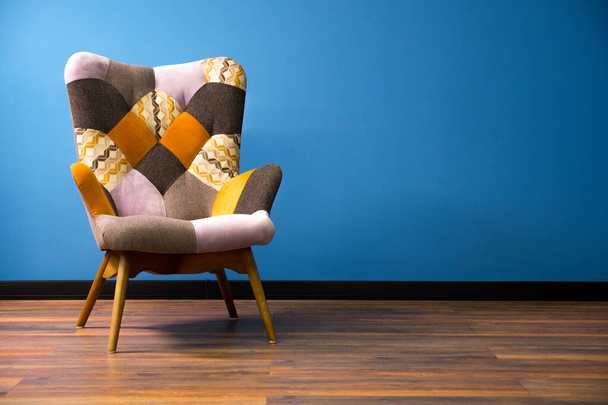 Tyhjä moderni tuoli puulattialla. Kiinteä seinä kontrasti jalkalistalla tausta. Yksi sisätilojen esine. Vintage tuoli puujalat. Skandinavian sisustus monivärinen tuoli
 - Valokuva, kuva