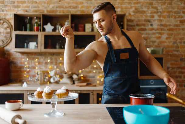 nackt Ehemann in Schürze Kochen Dessert mit Sahne auf der Küche. nackt männliche Person bereitet Frühstück zu Hause, Nahrungsmittelzubereitung ohne Kleidung - Foto, Bild