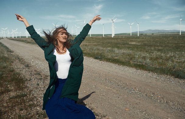 Mujer con el pelo largo junto a la turbina de viento con la w
 - Foto, Imagen