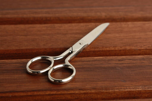 сшивание ножниц на деревянном фоне
 - Фото, изображение