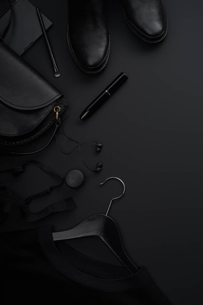 Black monochromatic clothes and accessories with beauty equipment on dark background. Black friday sale concept  - Zdjęcie, obraz