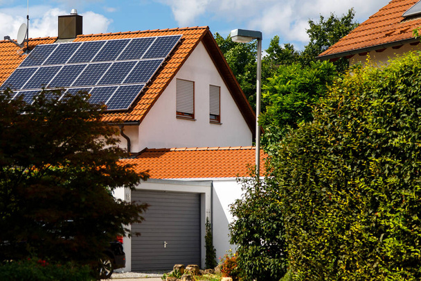 Painéis solares no telhado de azulejos de um edifício em um dia ensolarado brilhante. O conceito de um bom investimento, uma pechincha, uma superabundância de energia. Foco seletivo
. - Foto, Imagem