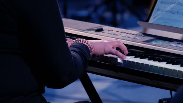Mãos de mulher tocando piano elétrico sob iluminação de palco colorido, close-up. Menina músico executar uma composição em uma estação de trabalho de música de teclado em uma noite de festa
. - Filmagem, Vídeo