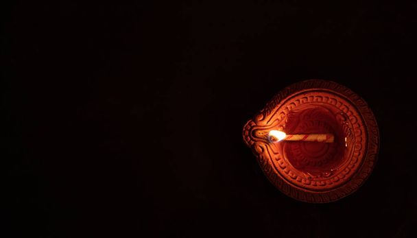 Gelukkig Diwali. Diya olielamp tegen donkere achtergrond, bovenaanzicht, - Foto, afbeelding