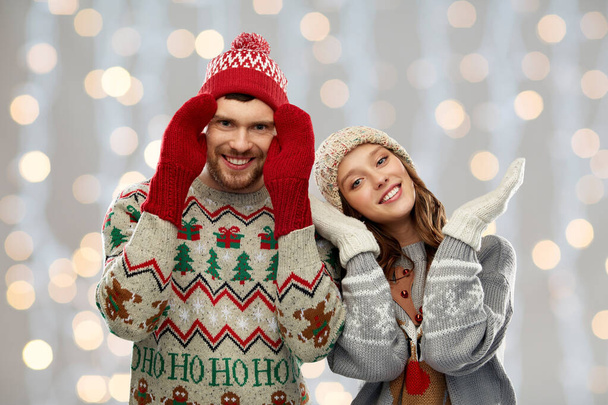 couple in ugly sweaters and mittens on christmas - Foto, immagini