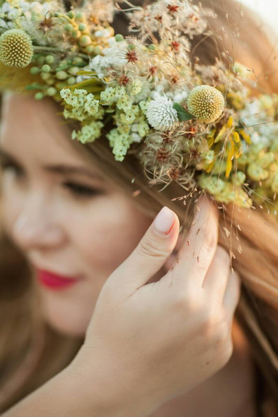 Close-up. Portrait of a pregnant woman in the sun. Young beautiful pregnant woman with a wreath on her head in the field. Motherhood. Warm autumn. - Foto, imagen