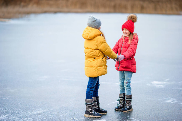 Adorables niñas patinando en la pista de hielo
 - Foto, Imagen