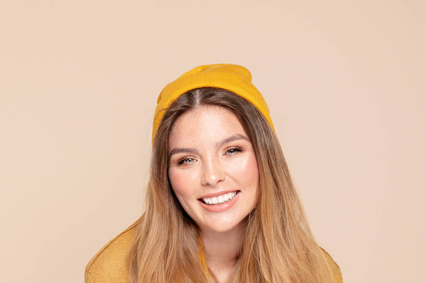 Módní usmívající se dívka v podzimní žluté čepici. - Fotografie, Obrázek