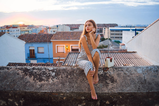 Young elegant barefoot woman posing on the street. - Valokuva, kuva