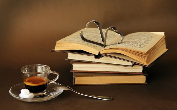 cup of coffee next to vintage books - Fotó, kép