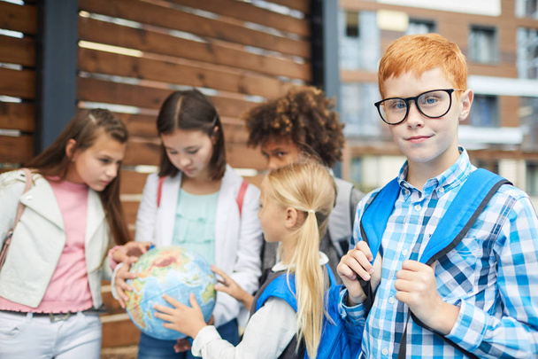 School children standing holding earth globe outdoors - Photo, Image