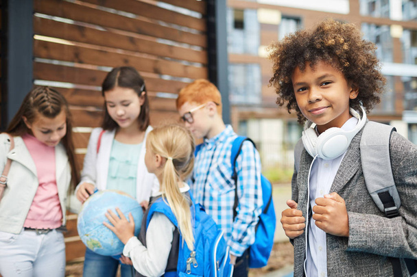 School children standing holding earth globe outdoors - Foto, Imagem