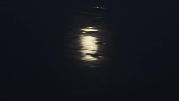 Kuu heijastuu joen liikkuvassa vedessä hämärässä.
 - Materiaali, video