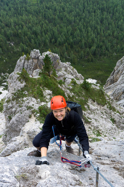 mulher em seus vinte anos escalando uma íngreme Via Ferrata nas Dolomitas de Alta Badia
 - Foto, Imagem