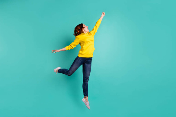 Full length body size photo of excited cheerful funny gorgeous attractive charming attractive girl wearing jeans denim rejocing with parasol motion isolated teal vivid color background - Fotoğraf, Görsel
