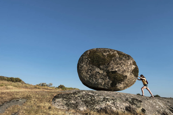 Dünya kayası iten bir kadın. Çalışan kadınların çabası için bir metafor. Yeni Sisyphus Bir Kadın - Fotoğraf, Görsel