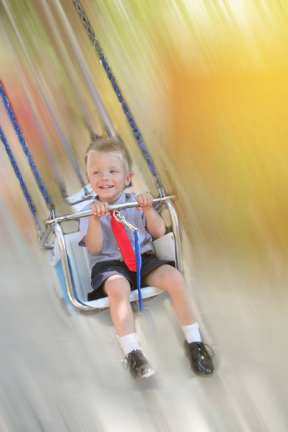 cheerful active kid riding on a swing - Foto, Imagem