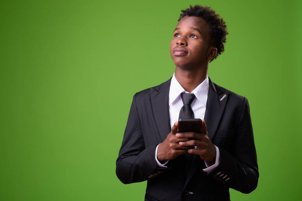 Young African businessman against green background - Φωτογραφία, εικόνα