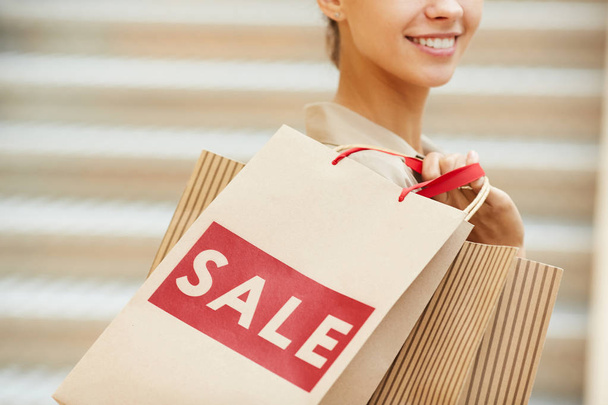 Close-up szczęśliwy cutomer gospodarstwa torby na zakupy zadowolonych zakupów podczas sprzedaży w sklepie - Zdjęcie, obraz